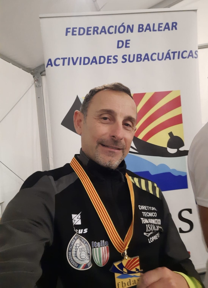 Raffaele Lo Prete con medaglia al collo davanti al banner della Federació Balear de Actividades Subacuáticas