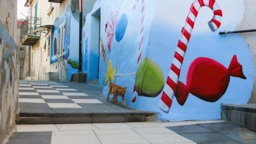 Vicolo di Belcastro decorato con murales di caramelle colorate e pavimentazione a scacchi